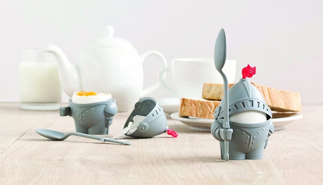 Two of the egg holders; one standing and assembled, one laying down with the helmet and spoon detached