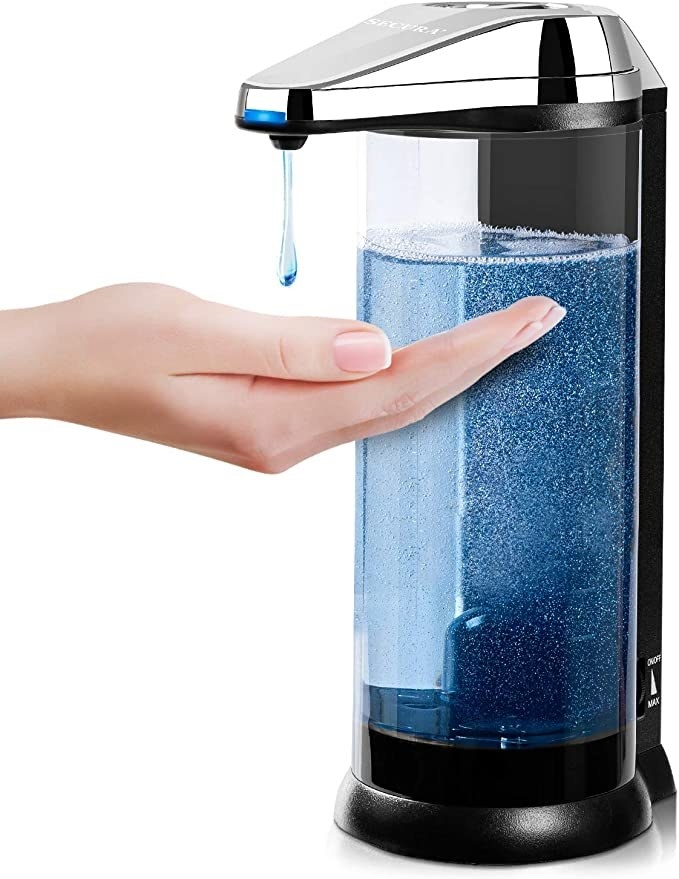 Hand under automatic soap dispenser with blue soap inside