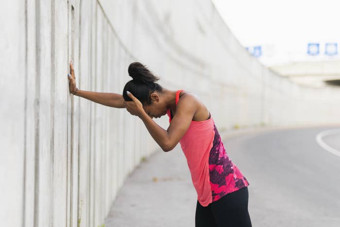 Young woman leaning on the concrete wall, taking a break