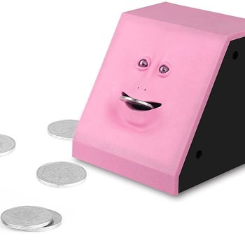 The pink piggybank with its mouth open and a coin inserted
