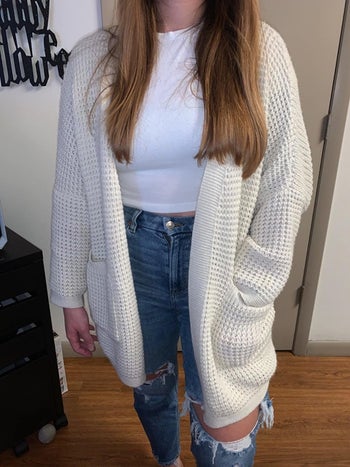 Reviewer wearing cardigan with hand in pocket