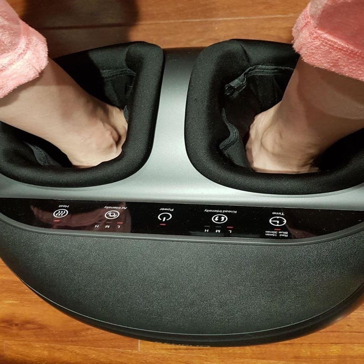 A reviewer photo of someone inserting their feet into the foot massager 