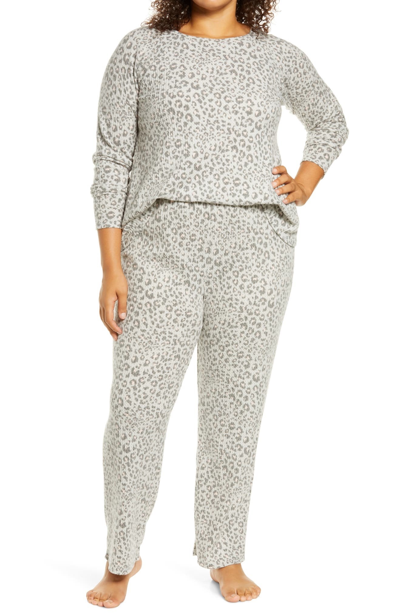 Model wearing the full-length pajama pants and long-sleeved shirt in grey with a darker grey leopard print on them