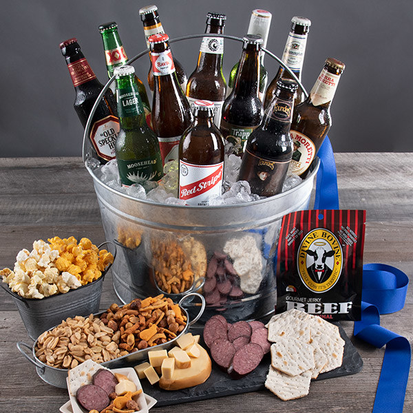 A steel bucket filled with 12 beers surrounded by an array of popcorn, jerky, cheese, peanuts, and crackers 