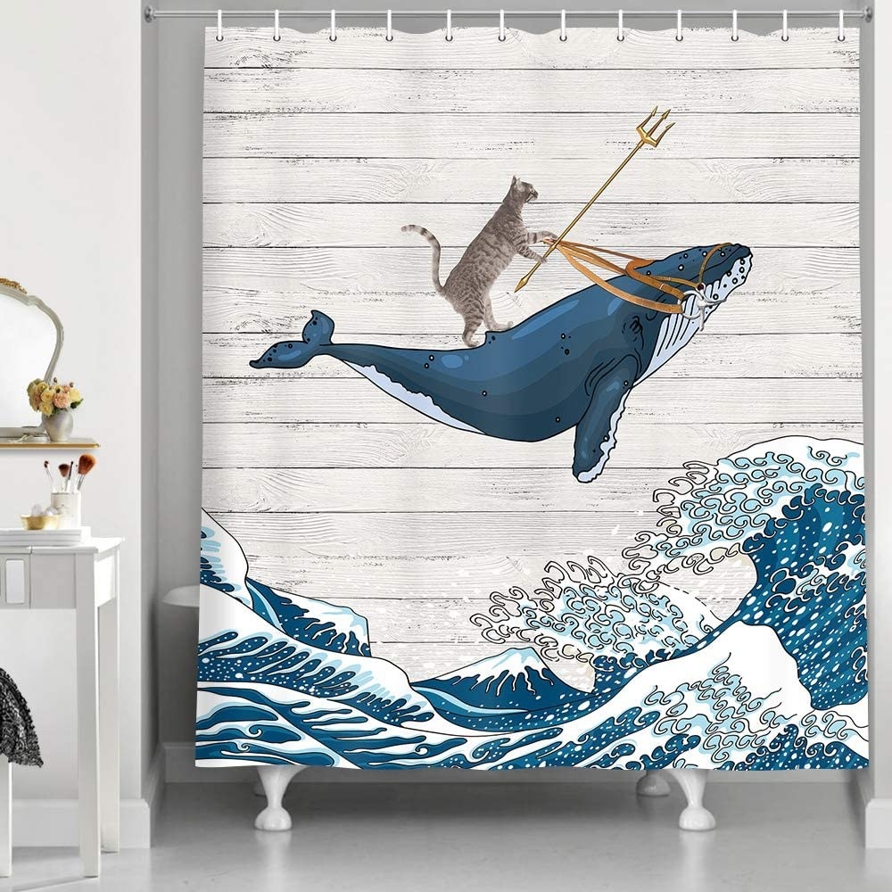 The shower curtain with an illustration of a cat riding a whale and holding a trident