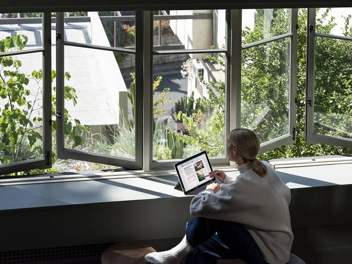 Une personne utilisant le Surface Pro 7 sur un comptoir près d’une fenêtre