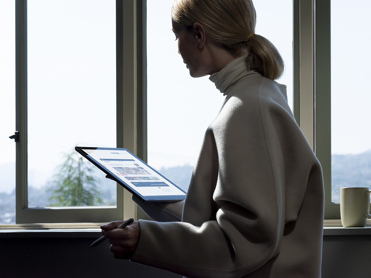 A person using the Surface pen to work on their Surface laptop