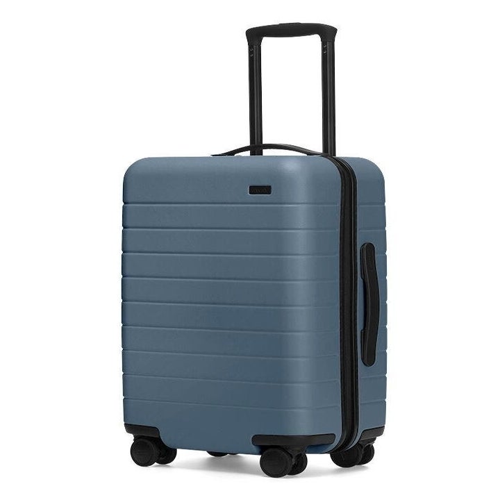 A light blue carry-on suitcase with a hard shell