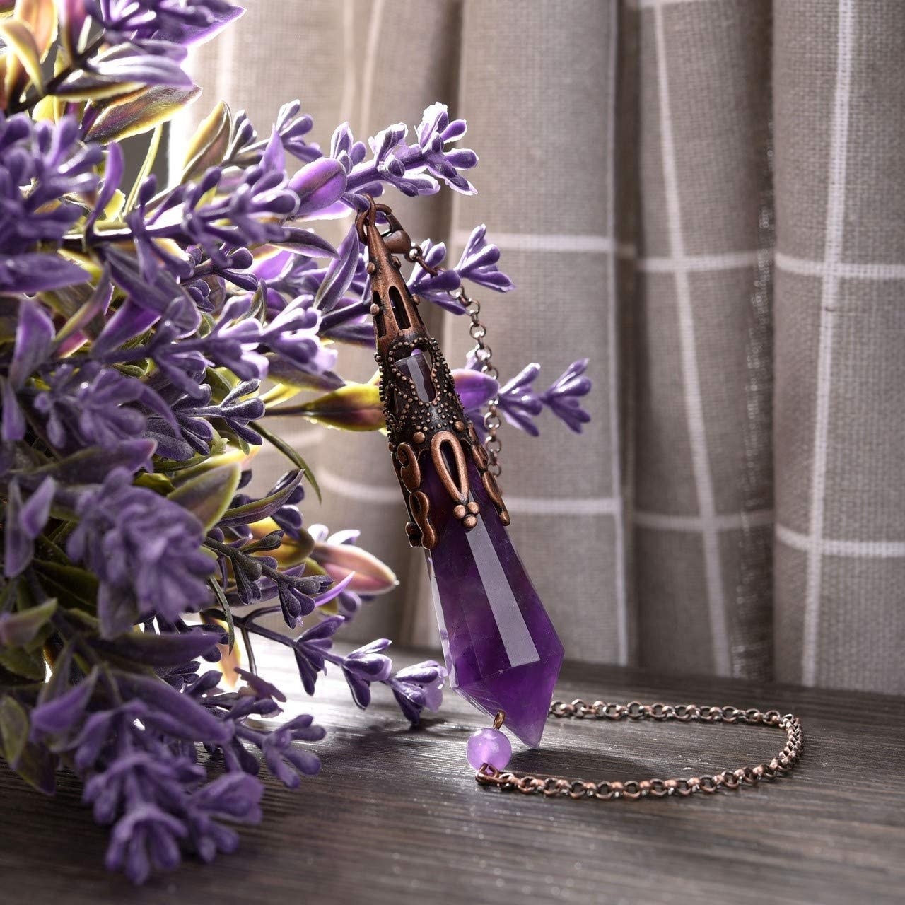 the amethyst divination pendulum displayed against lavender 