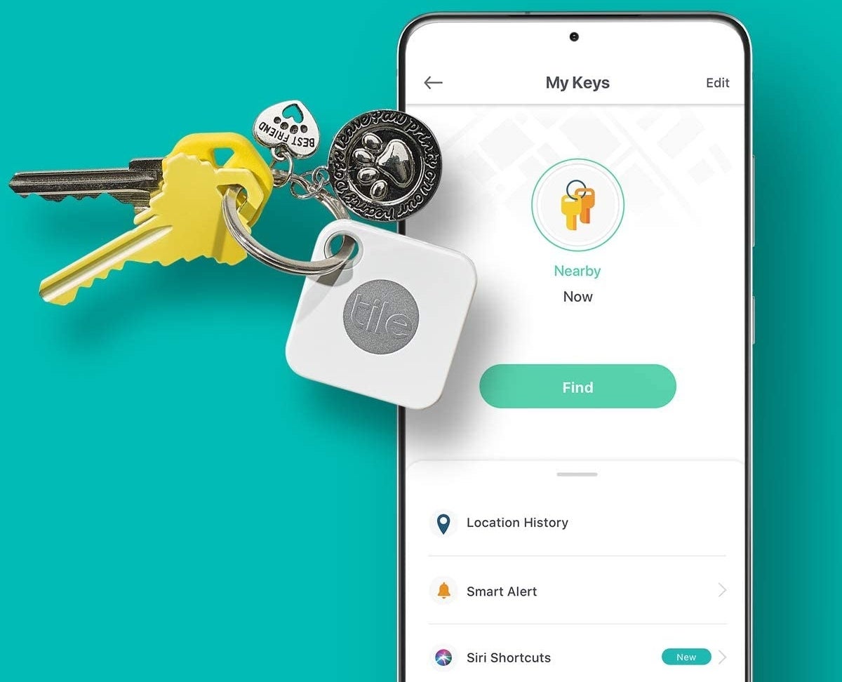 A Tile on a key ring with keys next to a phone displaying the app