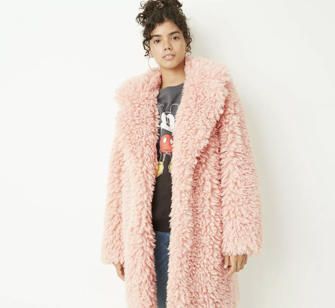 model wears pink faux fur jacket