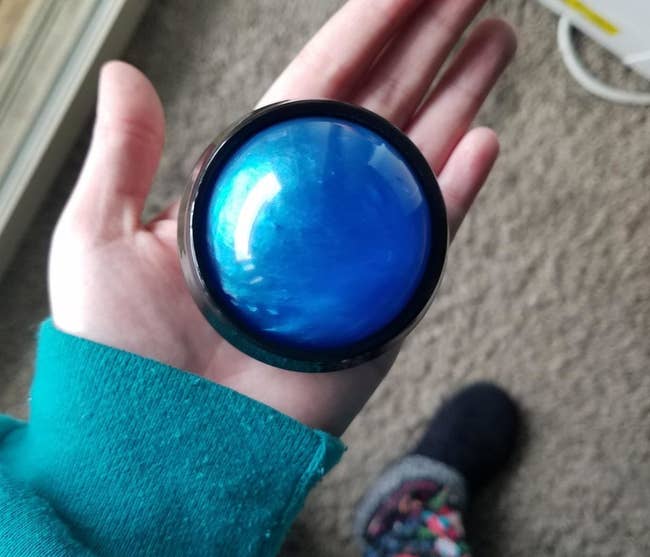 Reviewer hand holding the blue massage ball