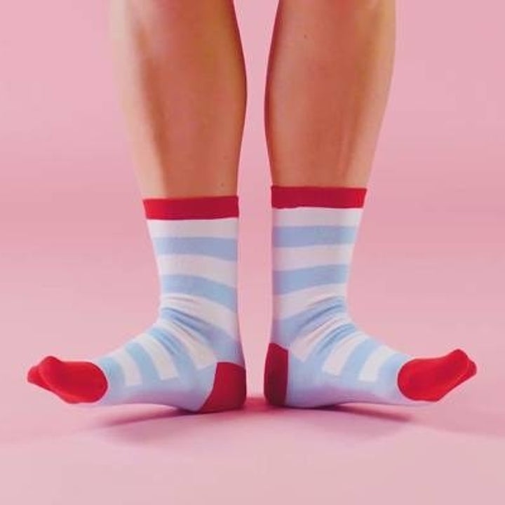 A model wearing a pair of blue and white striped socks with red trim