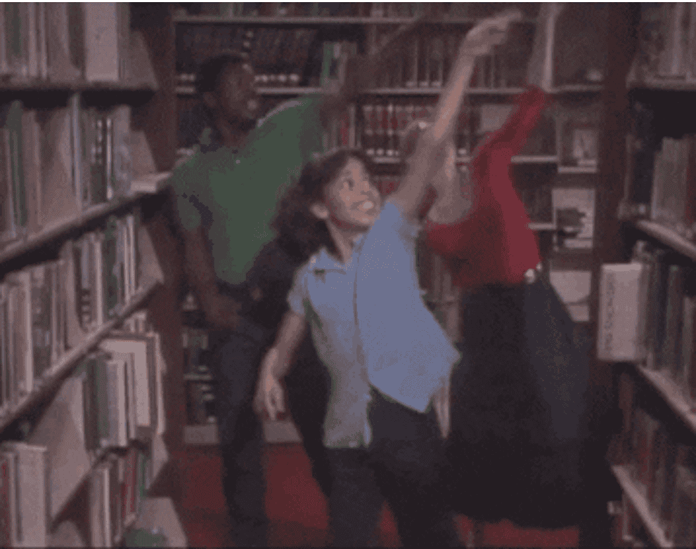 Gif of three people dancing in a library and pointing at books