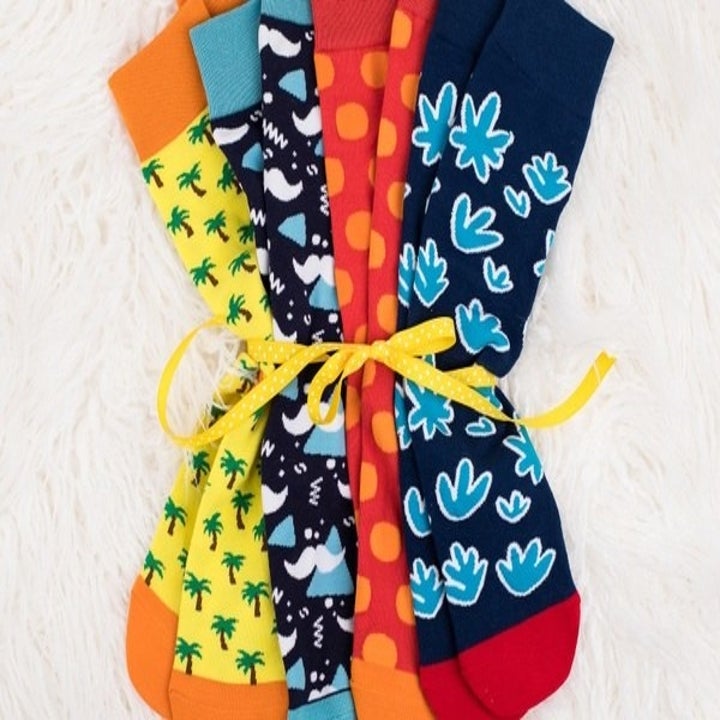 Four pairs of vibrant, patterned socks tied together with a ribbon 