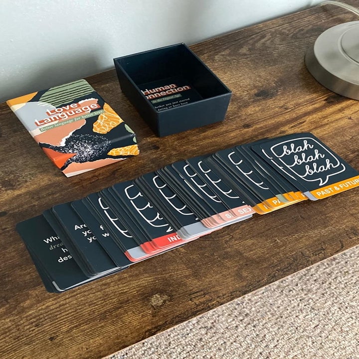 A reviewer photo of the open game box and the game cards fanned out on a table 