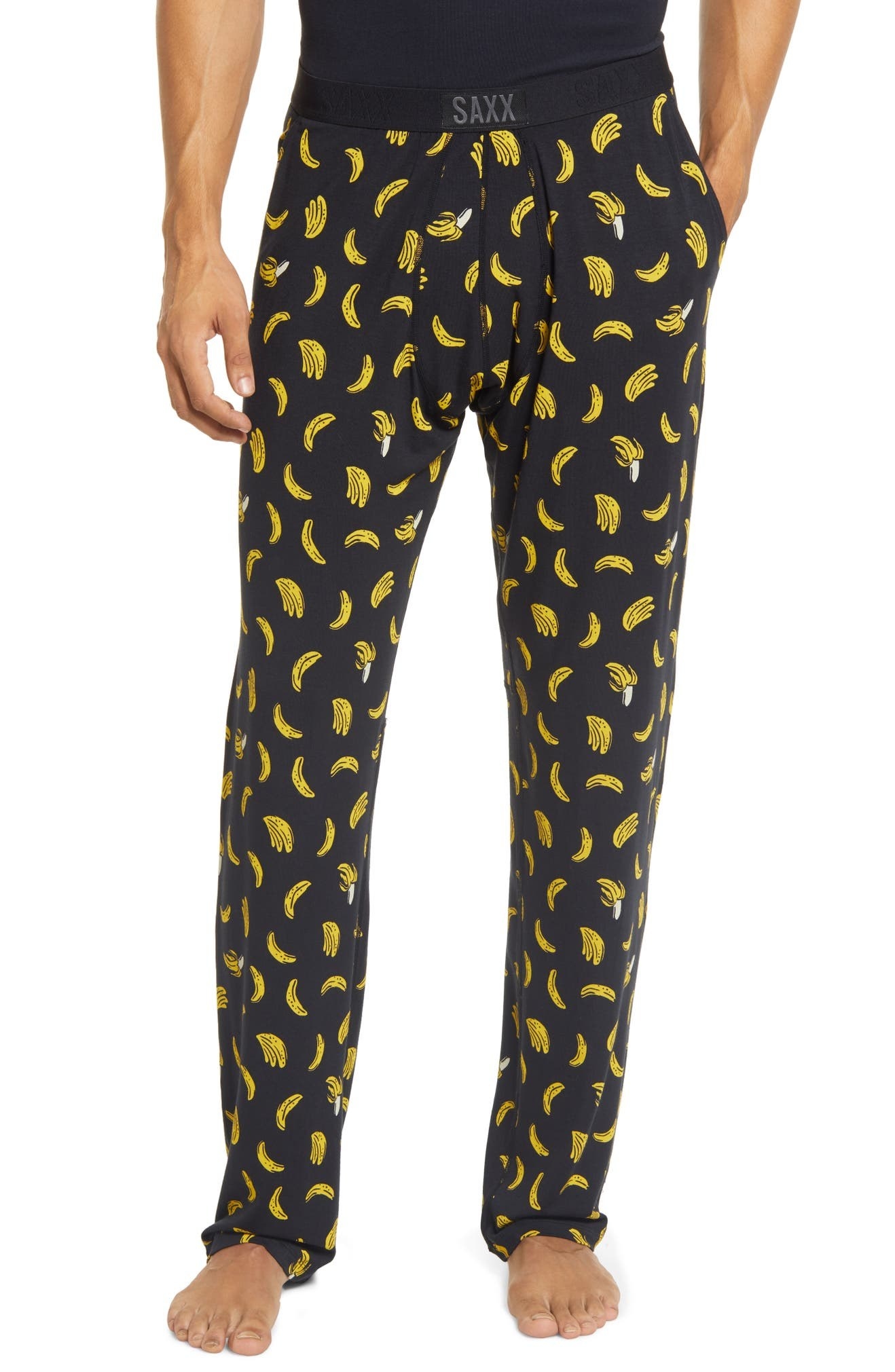 Model wearing the full-length pants in black with illustrations of bananas on them