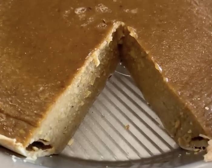 A pumpkin pie with a slice missing