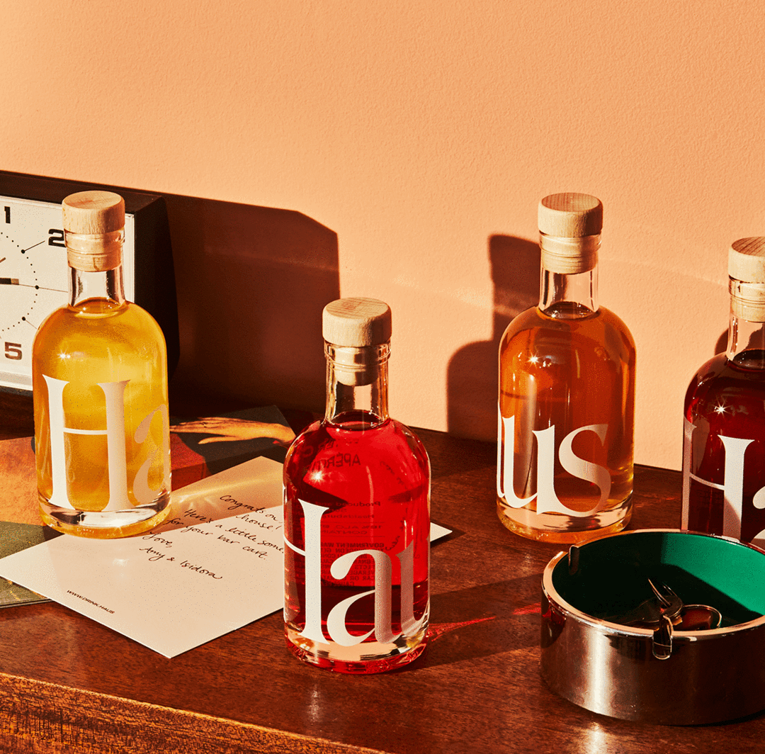 Four bottles of Haus styled on a table