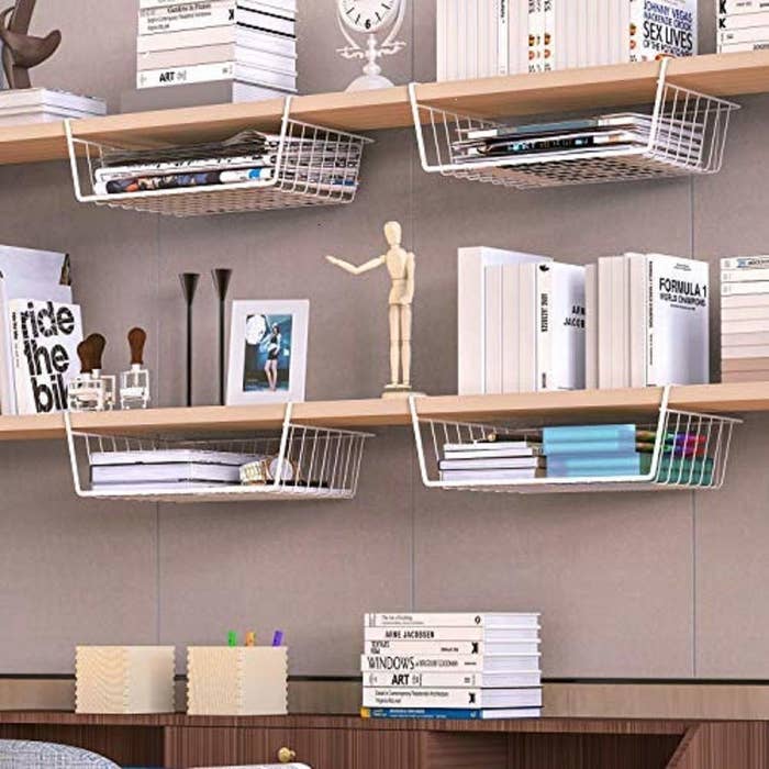 Wire storage baskets clipped on to shelves.