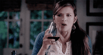 A woman drinking a large pour of red wine