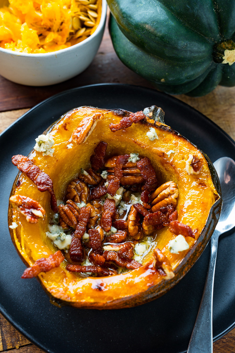 A half of an acorn squash, roasted and topped with blue cheese, pecans, and bacon.