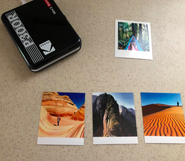 Reviewer photo showing the mobile printer next two four prints 