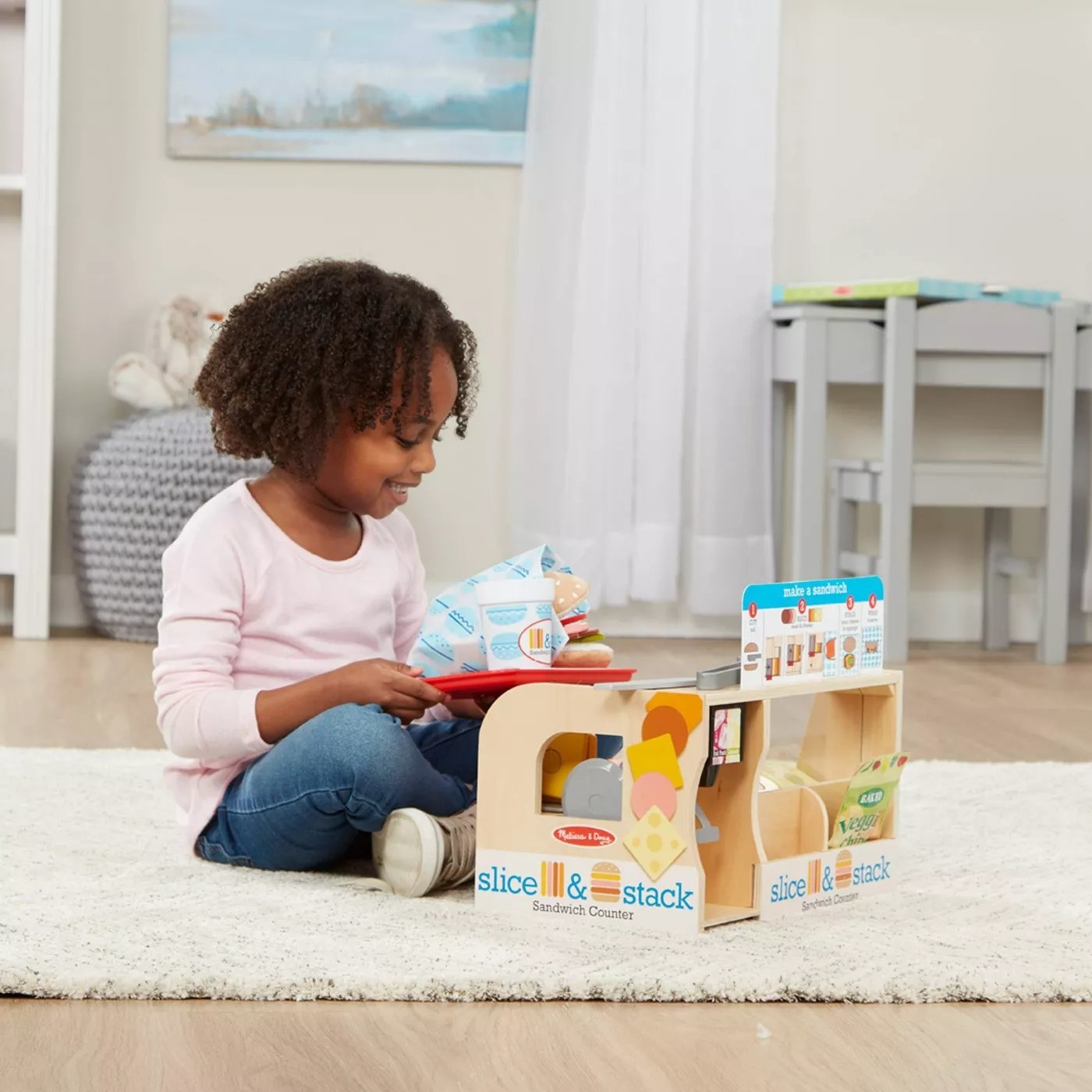 A child playing with the toy sandwich counter