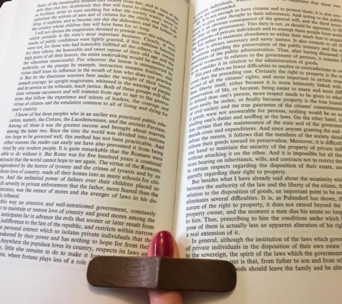 Reviewer using the book page holder to prop their book open while they read