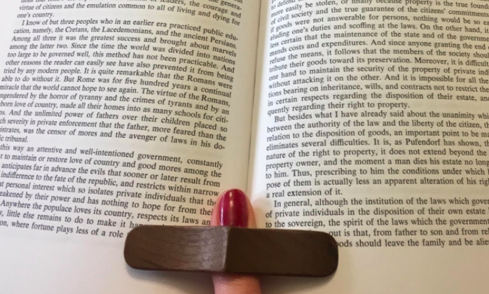 Reviewer using the book page holder to prop their book open while they read