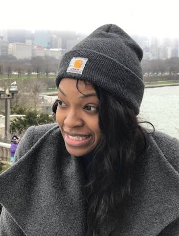 Reviewer in a gray foldover beanie with the Carhartt logo stitched in front 
