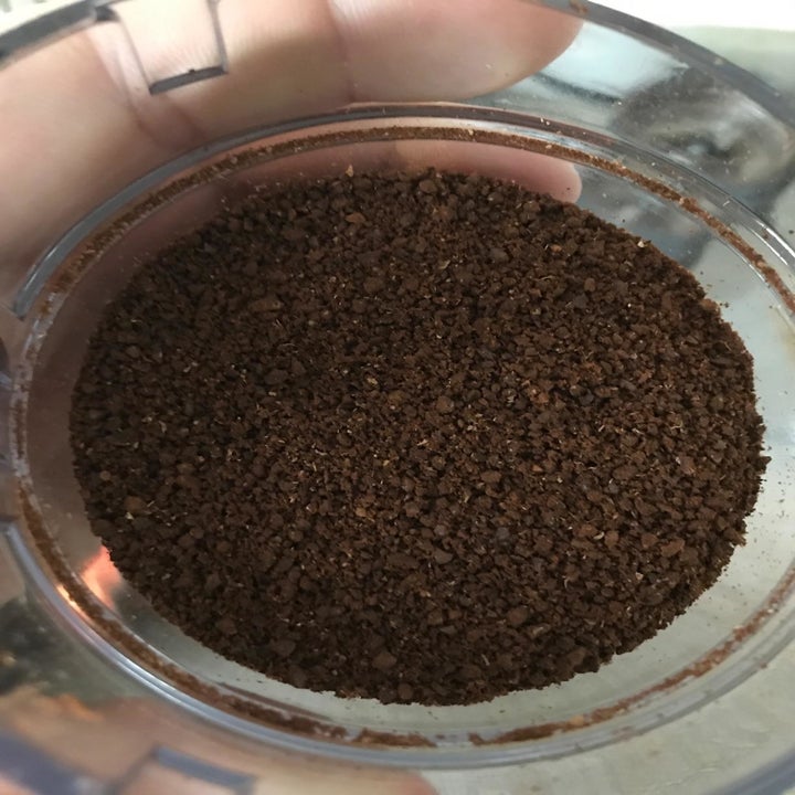 The same reviewer displaying freshly ground coffee