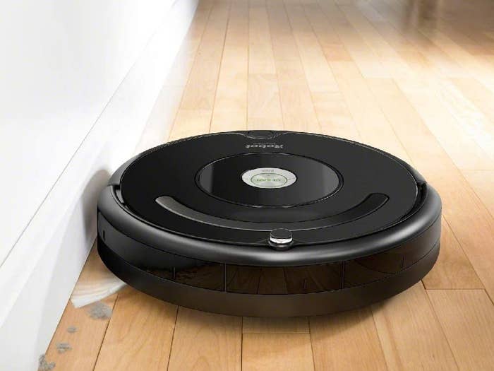 An Roomba vacuuming a hardwood floor