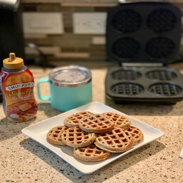 Neatly stacked waffles on a white plate after reviewer made them with the same waffle maker
