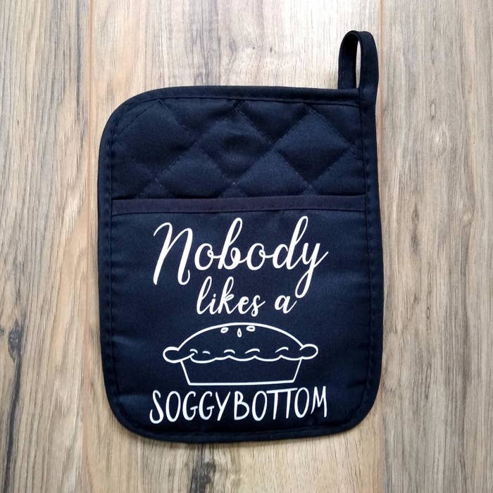 a blue quilted pot holder with a pie on it and the words &quot;nobody likes a soggy bottom&quot;