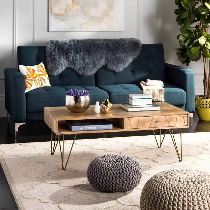 The mango-wood coffee table with iron legs, a drawer, and an open shelf