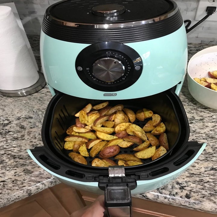 Reviewer cooks golden potatoes in a blue air fryer
