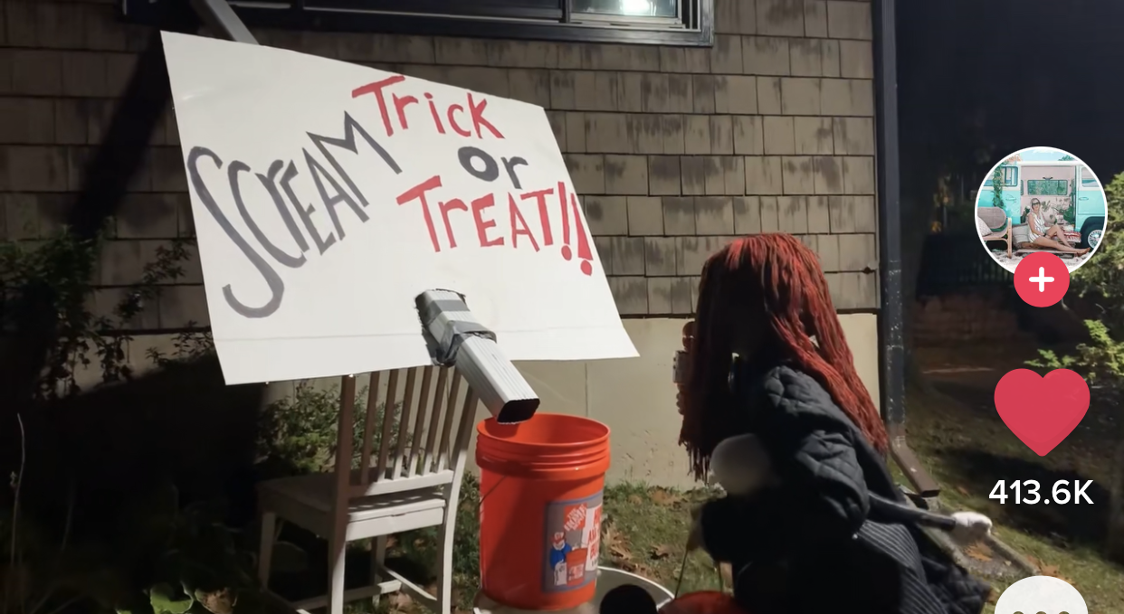 Candy chute with an attached signed that says 'Scream Trick Or Treat!!'