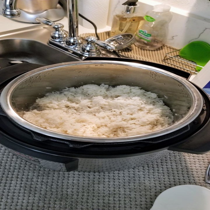 Reviewer shows cooked rice in silver Instant Pot on kitchen counter
