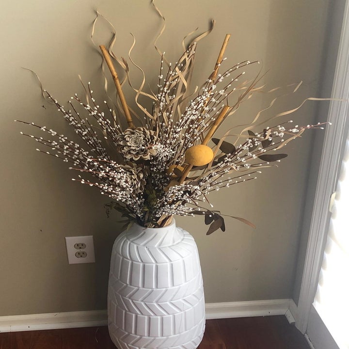 Reviewer photo of the faux flowers as part of a larger floral arrangement in a large white vase