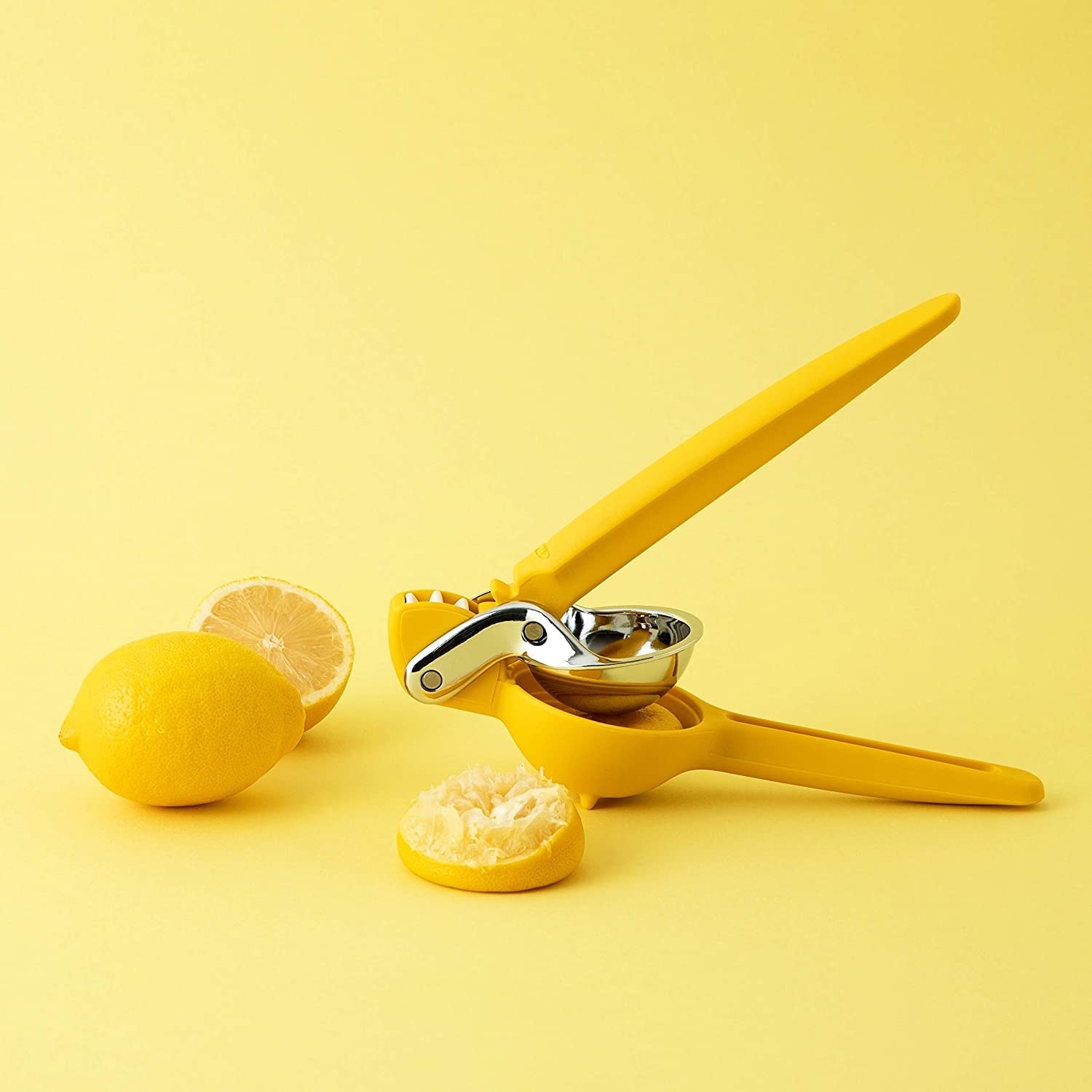Yellow citrus juicer next to lemon slices