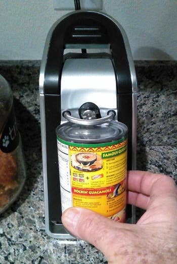 Reviewer places can of refried beans under black electric can opener