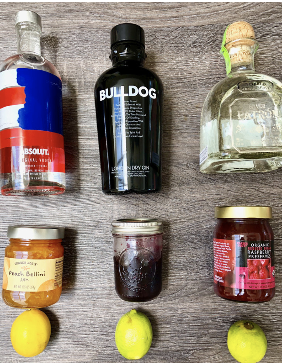 Liquor, jam, and citrus set out on a table
