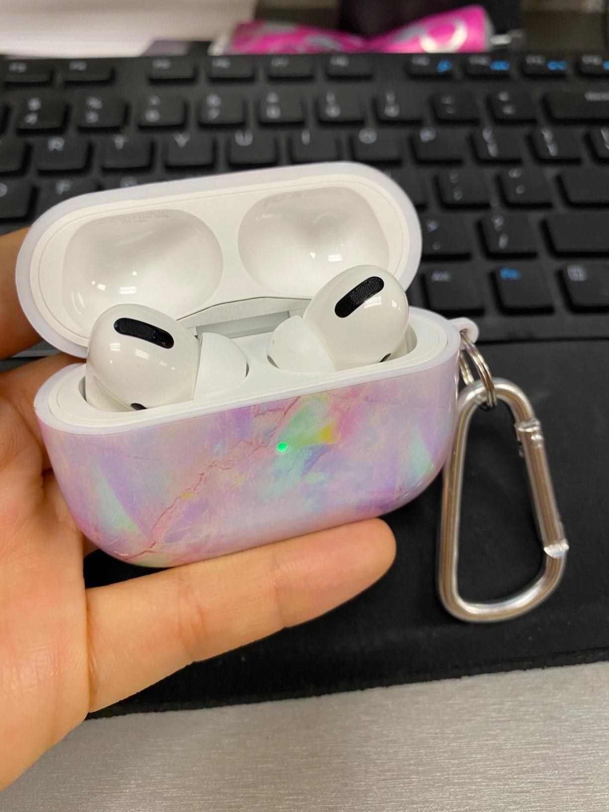 A reviewer holding the AirPods pro case