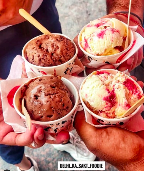 Several people holding cups of ice-cream