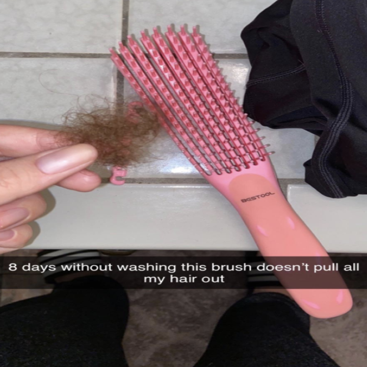 Reviewer photo of detangling brush in hand with a chunk of hair