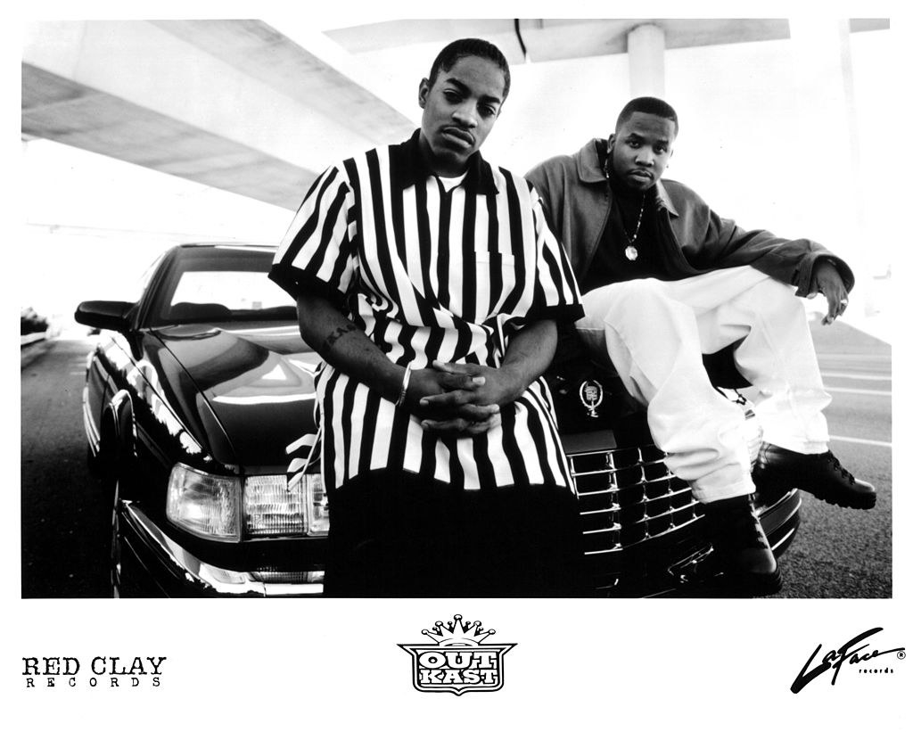 Outkast posing on top of a car in a black and white image in the early &#x27;90s