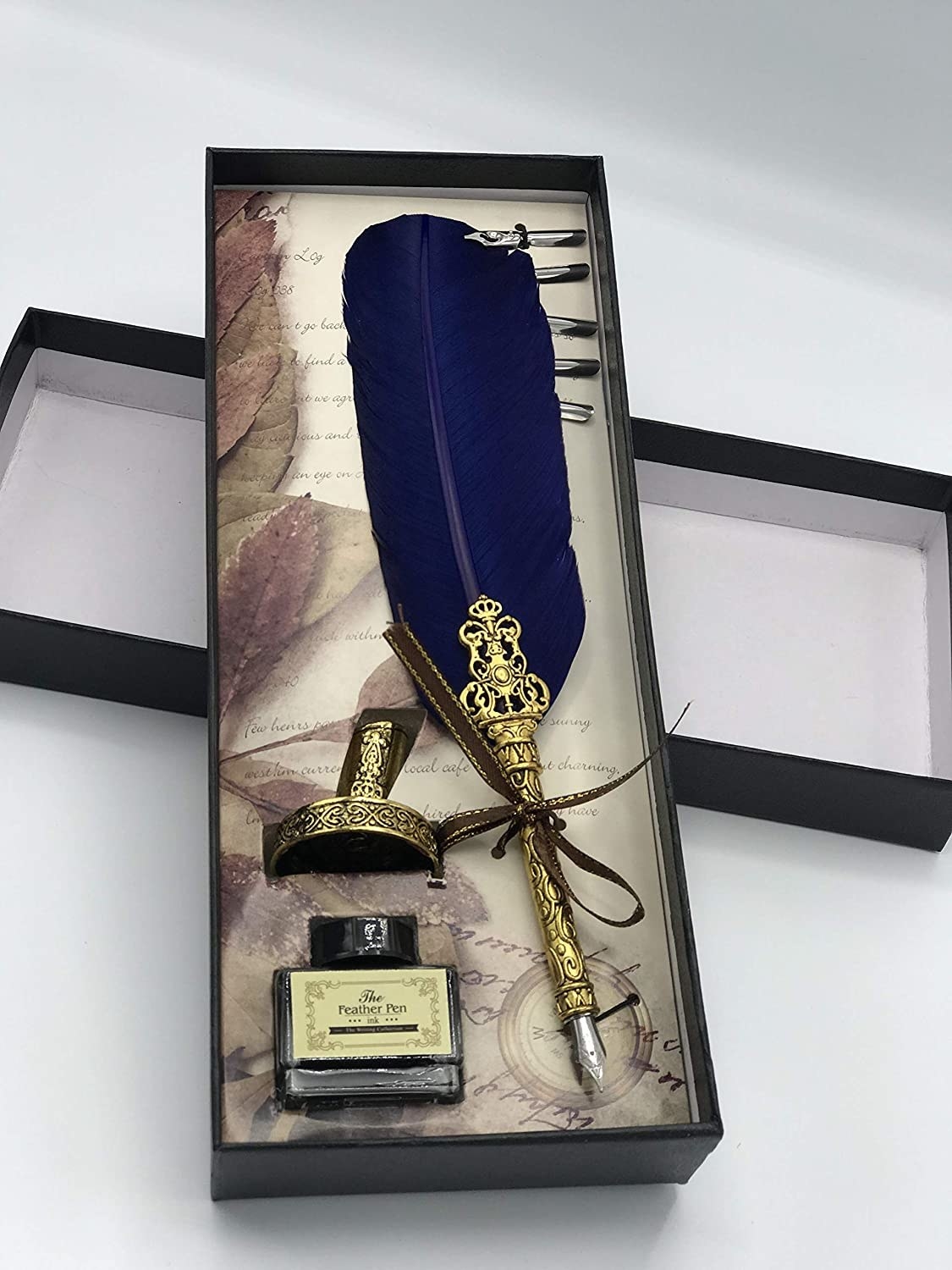The quill has a navy blue feather extension and gold plating with intricate detail leading up to the nib.