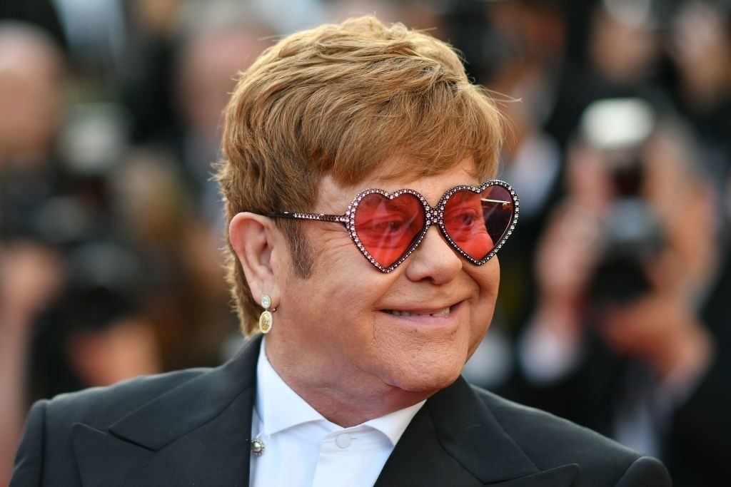 Elton John at the screening for &quot;Rocketman&quot; in 2019, smiling while wearing heart-shaped glasses
