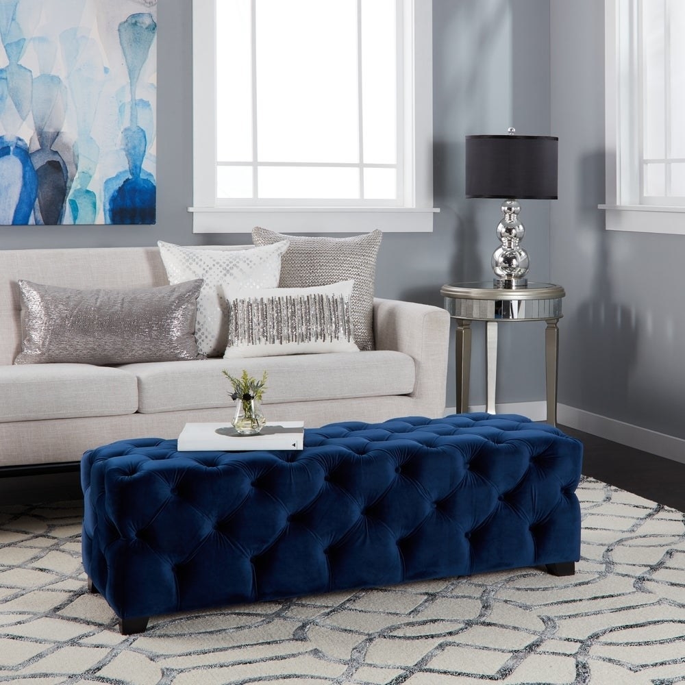 The tufted ottoman in navy blue